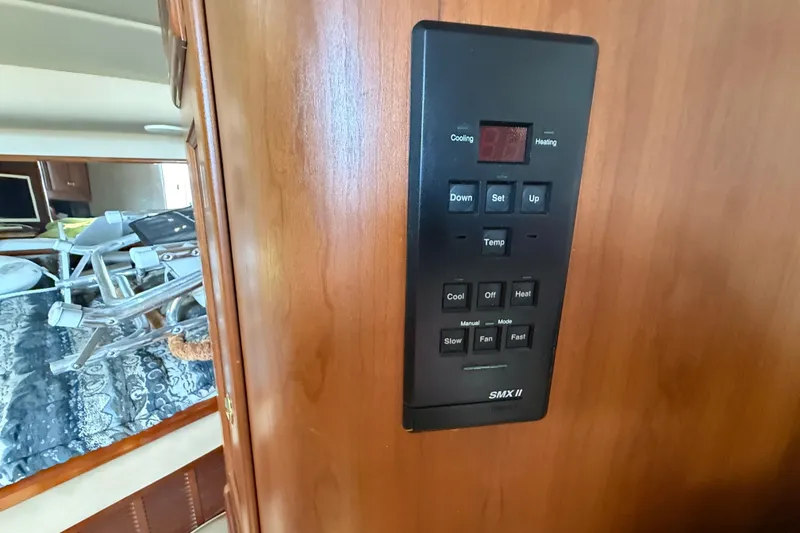 Slide: The Image of Control panel inside 2002 Rampage 30 Express boat, featuring temperature and fan settings. - 26