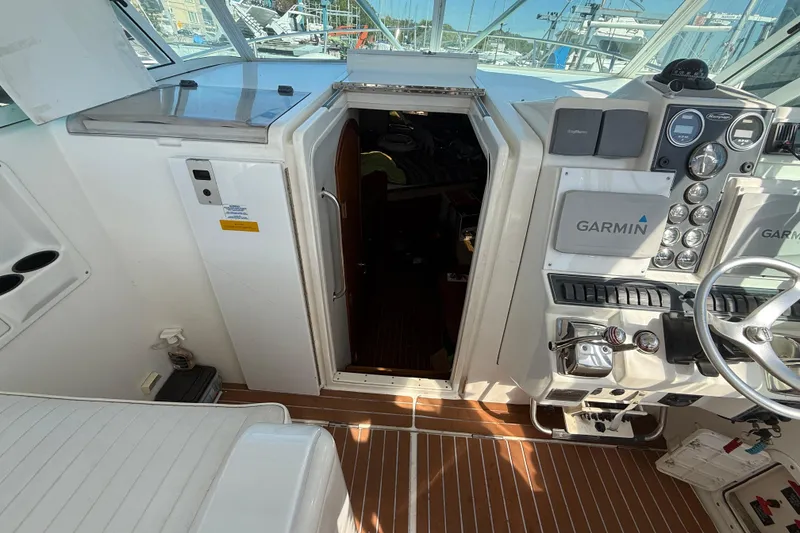Slide: The Image of 2002 Rampage 30 Express boat cockpit with Garmin navigation system and open cabin door. - 7