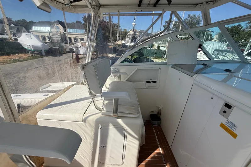 Slide: The Image of 2002 Rampage 30 Express boat interior with white seating and control panel. - 8