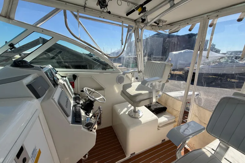 Slide: The Image of 2002 Rampage 30 Express boat cockpit with steering wheel and seating. - 9