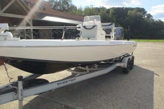 Slide: The Image of 2021 Skeeter SX240 boat on trailer, parked outdoors in sunny setting. - 11