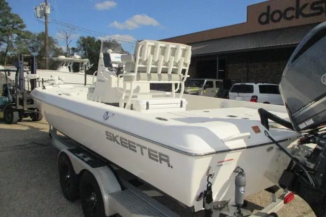 Slide: The Image of 2021 Skeeter SX240 boat on trailer, parked outside a dealership. - 2