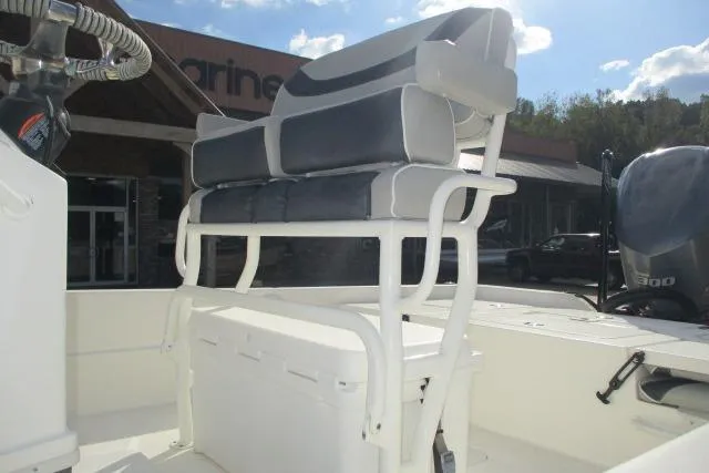 Slide: The Image of 2021 Skeeter SX240 boat with cushioned seating and outboard motor in a marina setting. - 3