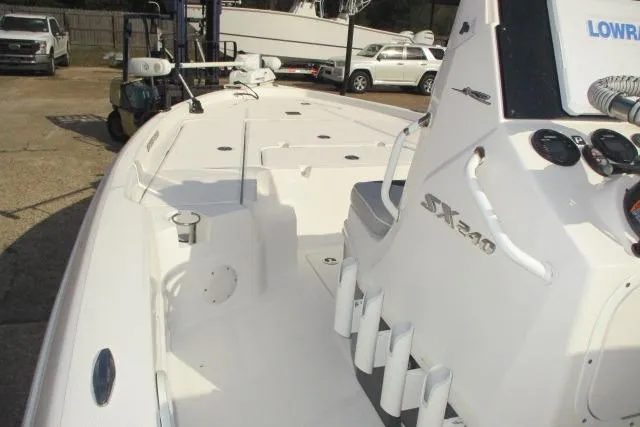 Slide: The Image of 2021 Skeeter SX240 boat interior with console and seating, showcasing fishing rod holders. - 5