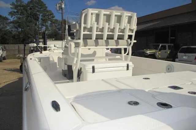 Slide: The Image of 2021 Skeeter SX240 boat interior with seating and storage, parked outdoors. - 7