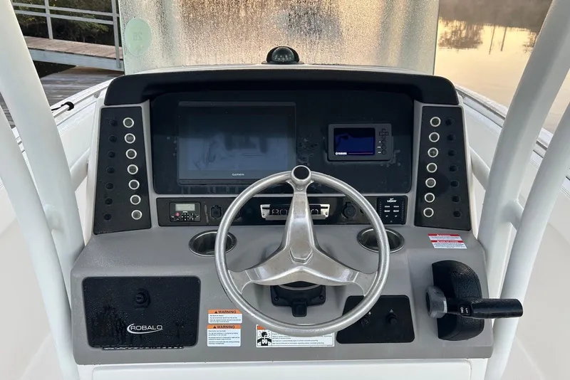 Slide: The Image of 2020 Robalo R230 Center Console boat dashboard with steering wheel and navigation controls. - 4
