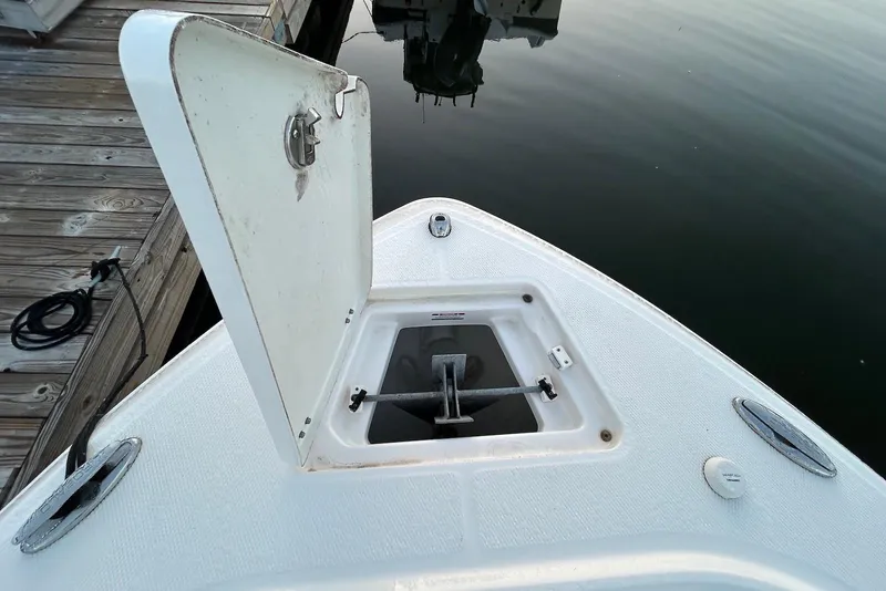 Slide: The Image of Open anchor compartment on 2020 Robalo R230 Center Console boat at dock. - 9