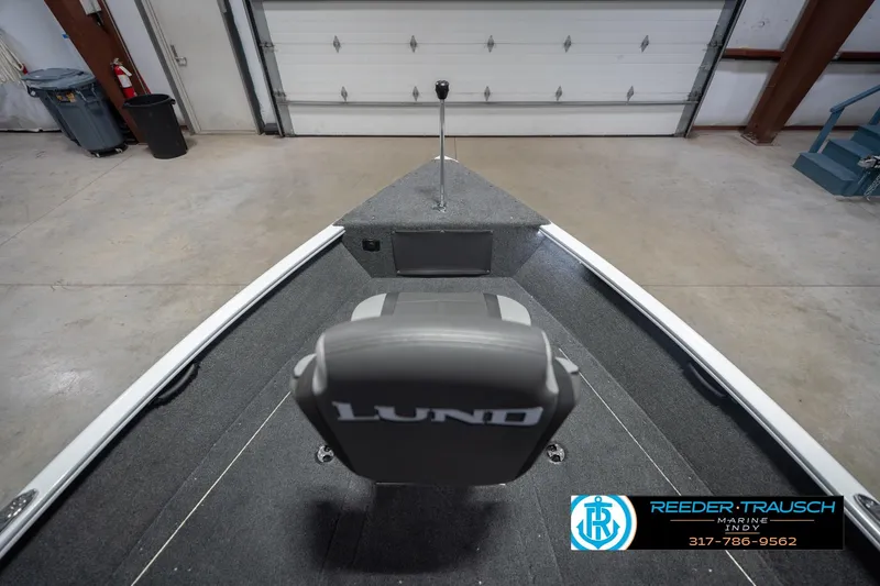 Slide: The Image of 2026 Lund 1675 Adventure Sport boat interior with gray seating in a garage. - 18