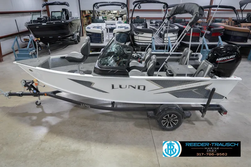 The Image of 2026 Lund 1675 Adventure Sport boat in showroom, featuring sleek design and Mercury engine. - 2