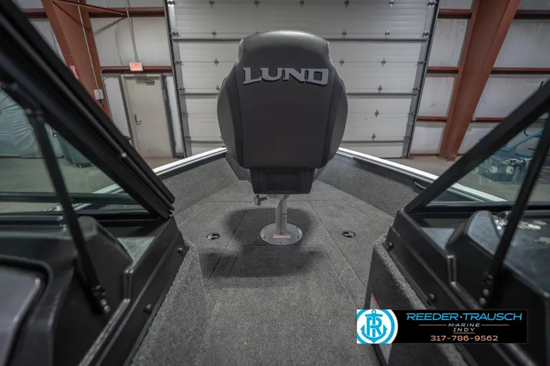Slide: The Image of 2026 Lund 1675 Adventure Sport boat interior with central seat in a garage setting. - 31