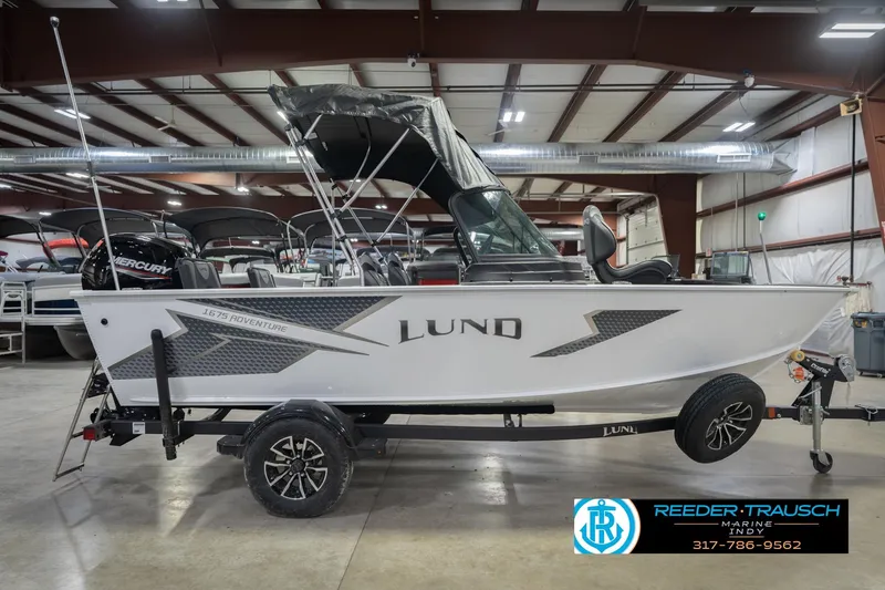 Slide: The Image of 2026 Lund 1675 Adventure Sport boat in showroom, side view with trailer. - 7