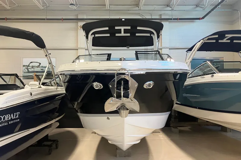 Slide: The Image of 2026 Cobalt R6 boat displayed indoors, flanked by other boats. - 2