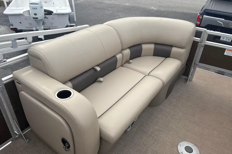 Slide: The Image of 2024 Sun Tracker SportFish 22 DLX pontoon boat with beige seating and cup holder. - 10