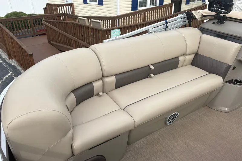Slide: The Image of 2024 Sun Tracker SportFish 22 DLX boat interior with beige seating and cup holder. - 11