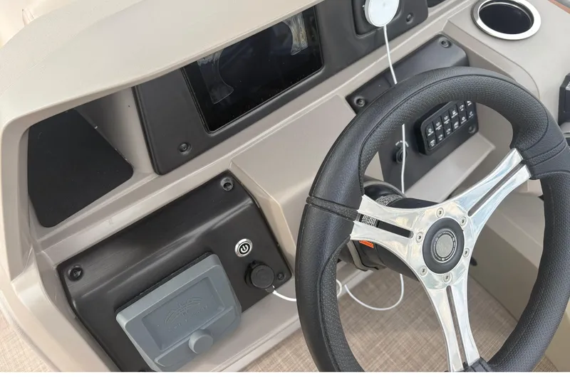 Slide: The Image of 2024 Sun Tracker SportFish 22 DLX dashboard with steering wheel and control panel. - 18