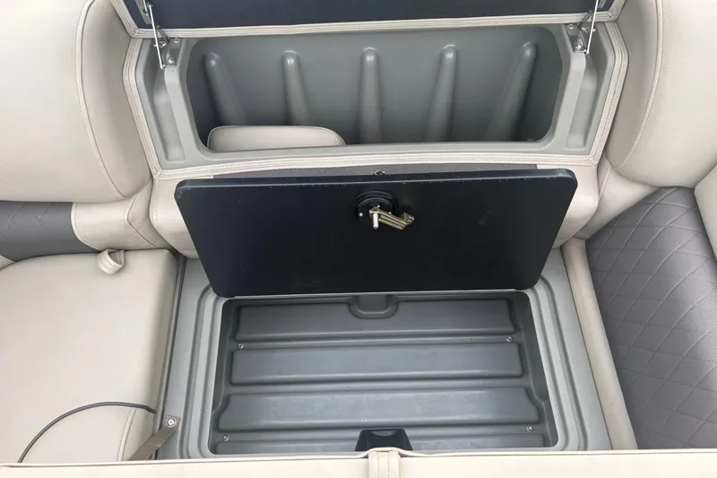 Slide: The Image of 2024 Sun Tracker SportFish 22 DLX storage compartment with secure lock and key. - 22