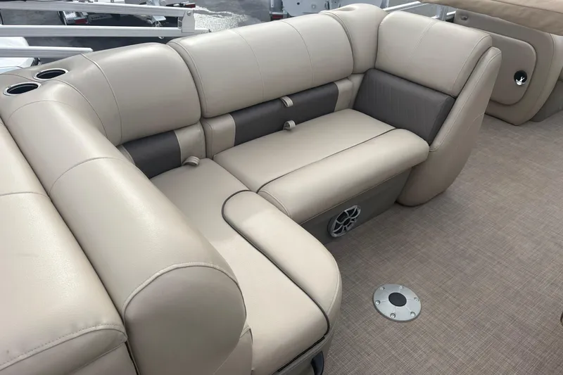 Slide: The Image of 2024 Sun Tracker SportFish 22 DLX boat interior with beige seating and cup holders. - 23