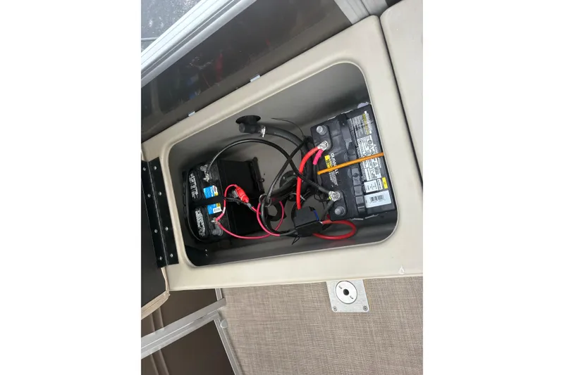 Slide: The Image of 2024 Sun Tracker SportFish 22 DLX battery compartment with wiring and connections. - 25