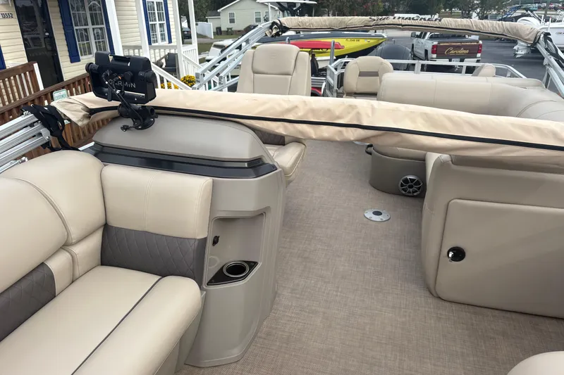 Slide: The Image of 2024 Sun Tracker SportFish 22 DLX pontoon boat interior with beige seating and modern amenities. - 9