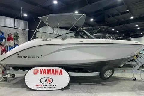 Slide: The Image of 2025 Yamaha Boats SX220 displayed indoors on a trailer. - 1