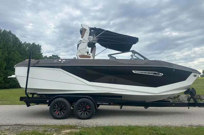 Slide: The Image of 2025 Nautique Super Air Nautique G23 boat on trailer, sleek design, overcast sky. - 10
