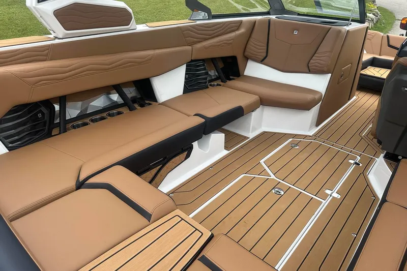 Slide: The Image of 2025 Nautique Super Air Nautique G23 interior with tan seating and teak-style flooring. - 15