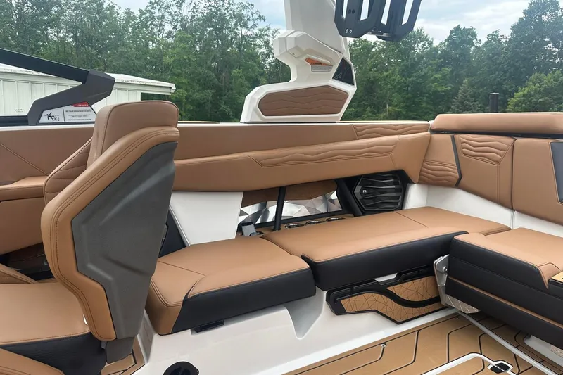 Slide: The Image of Luxurious interior of 2025 Nautique Super Air Nautique G23 with tan and black seating. - 19