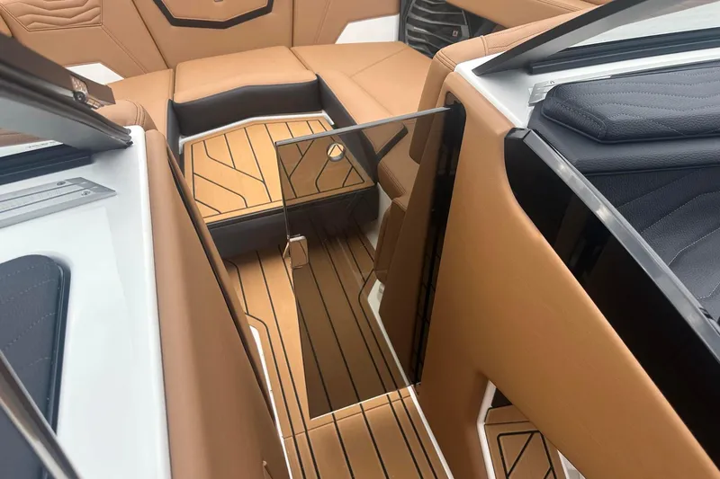 Slide: The Image of 2025 Nautique Super Air Nautique G23 interior with tan upholstery and sleek design. - 25