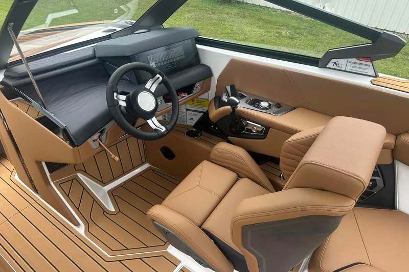 Slide: The Image of 2025 Nautique Super Air Nautique G23 interior with tan leather seats and modern dashboard. - 26