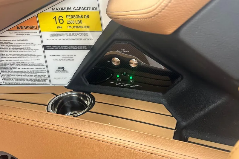Slide: The Image of 2025 Nautique Super Air Nautique G23 interior, capacity label, and control panel. - 28