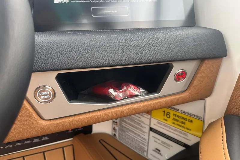 Slide: The Image of 2025 Nautique Super Air Nautique G23 dashboard with start/stop button and storage compartment. - 29