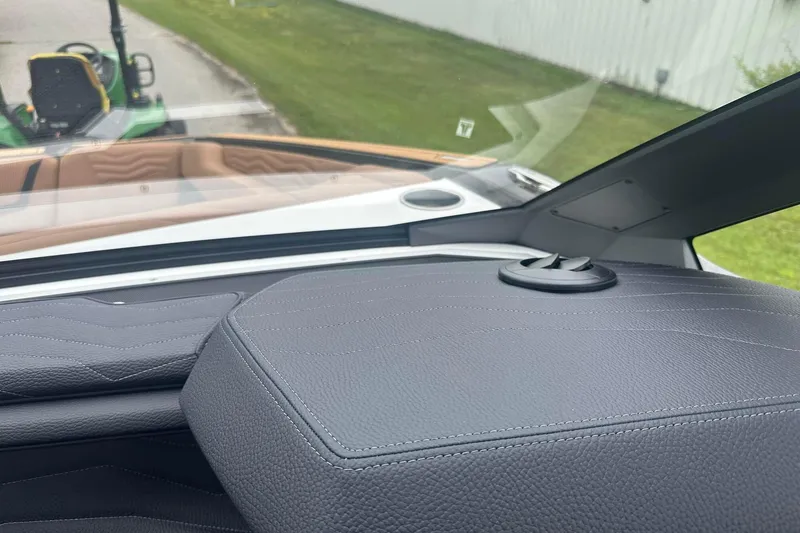 Slide: The Image of 2025 Nautique Super Air Nautique G23 dashboard with leather detailing and outdoor view. - 31