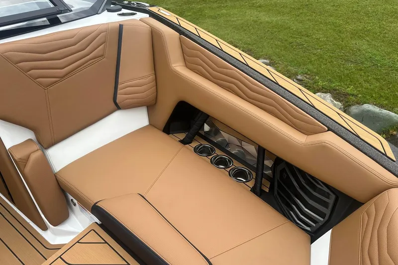 Slide: The Image of 2025 Nautique Super Air Nautique G23 interior with tan upholstery and cup holders. - 40