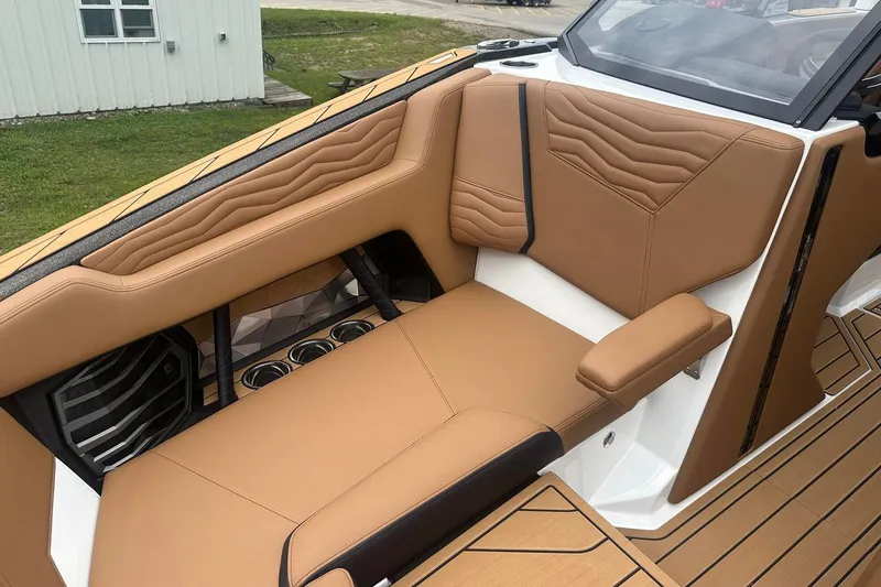 Slide: The Image of 2025 Nautique Super Air Nautique G23 interior with tan leather seating and cup holders. - 41
