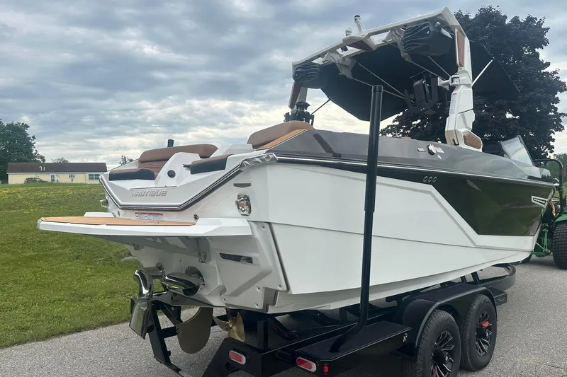 Slide: The Image of 2025 Nautique Super Air Nautique G23 boat on trailer, rear view, overcast sky. - 9