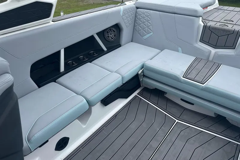 Slide: The Image of 2025 Nautique Super Air Nautique GS22 interior with gray cushioned seating and cup holders. - 17