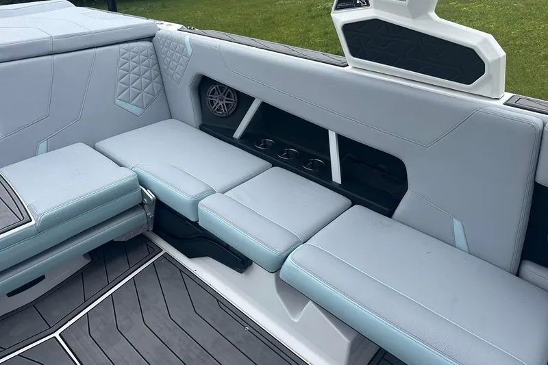 Slide: The Image of 2025 Nautique Super Air Nautique GS22 interior with light gray seating and cup holders. - 18