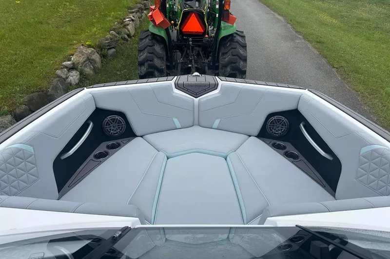 Slide: The Image of 2025 Nautique Super Air Nautique GS22 interior with plush seating and cup holders. - 23