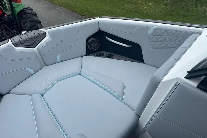 Slide: The Image of 2025 Nautique Super Air Nautique GS22 interior seating with modern design and cup holders. - 26
