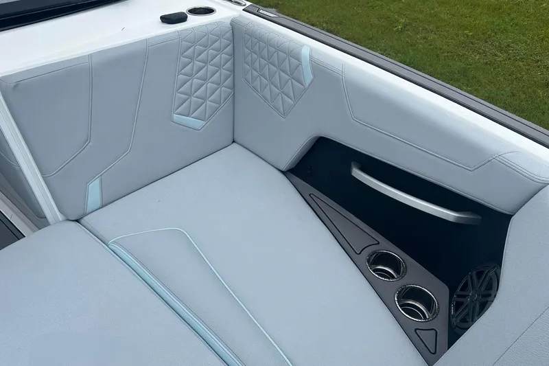 Slide: The Image of 2025 Nautique Super Air Nautique GS22 interior with gray upholstery and cup holders. - 27