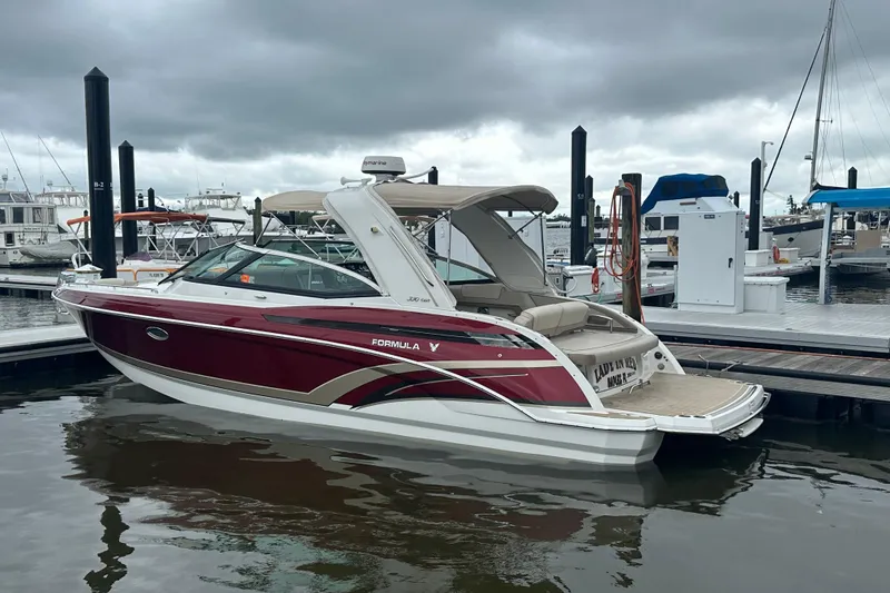 Slide: The Image of 2016 Formula 330 Crossover Bowrider docked at marina under cloudy skies. - 2