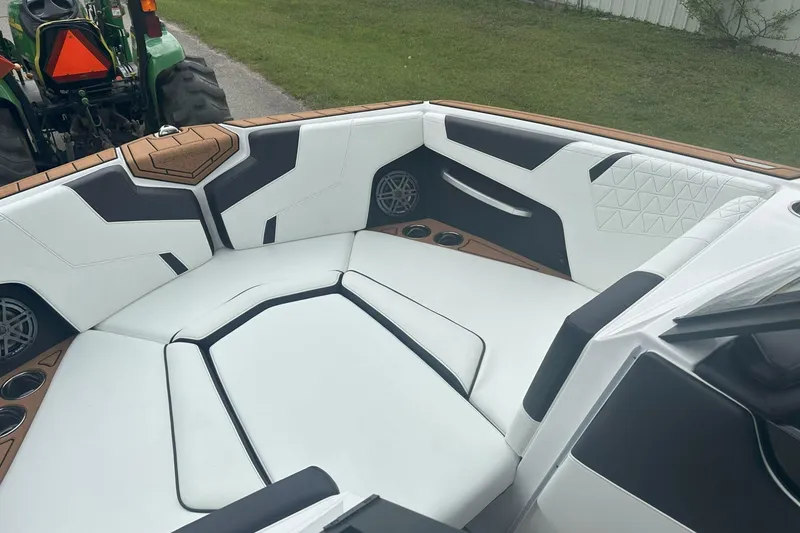Slide: The Image of 2025 Nautique Super Air Nautique GS22 boat interior with white and black seating. - 16