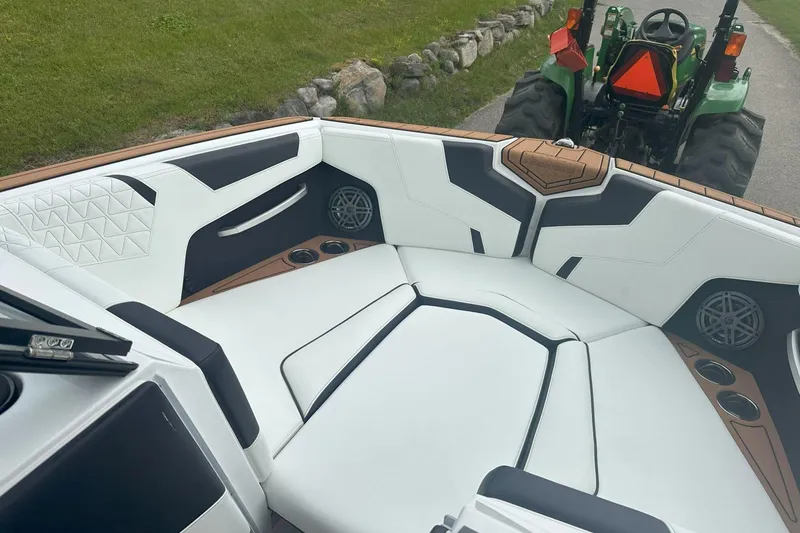 Slide: The Image of 2025 Nautique Super Air Nautique GS22 interior with white seating and cup holders. - 17