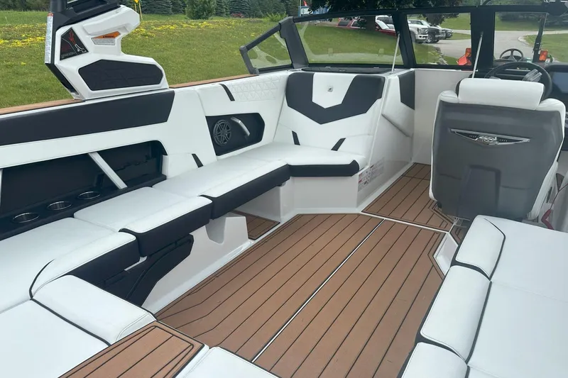 Slide: The Image of 2025 Nautique Super Air Nautique GS22 interior with white seating and teak-style flooring. - 24