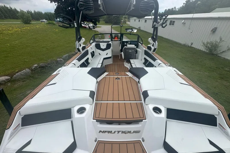 Slide: The Image of 2025 Nautique Super Air Nautique GS22 boat interior with white seating and wood accents. - 25