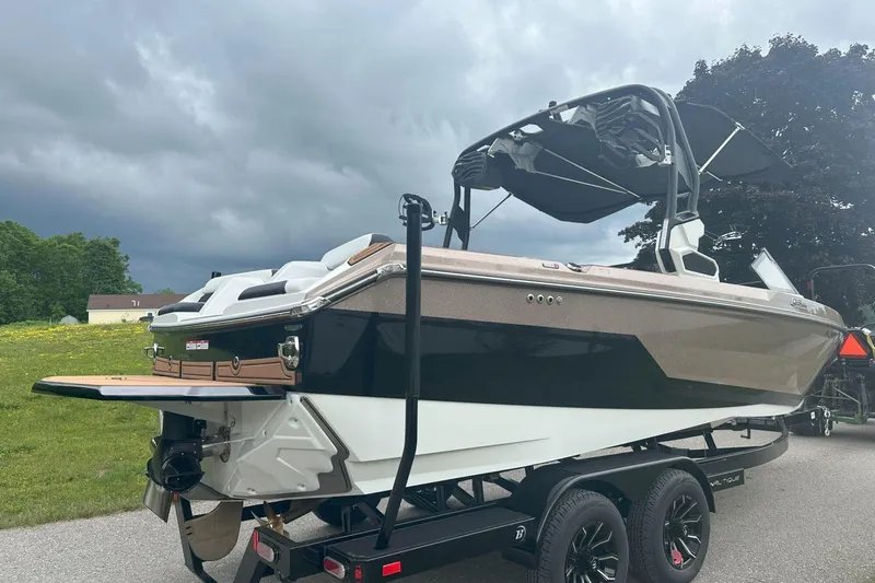 Slide: The Image of 2025 Nautique Super Air Nautique GS22 boat on trailer, under cloudy sky. - 5