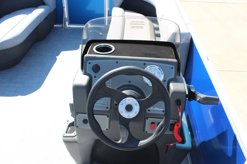 Slide: The Image of 2026 Sun Tracker Party Barge 16 DLX steering console with cup holder and gauges. - 11