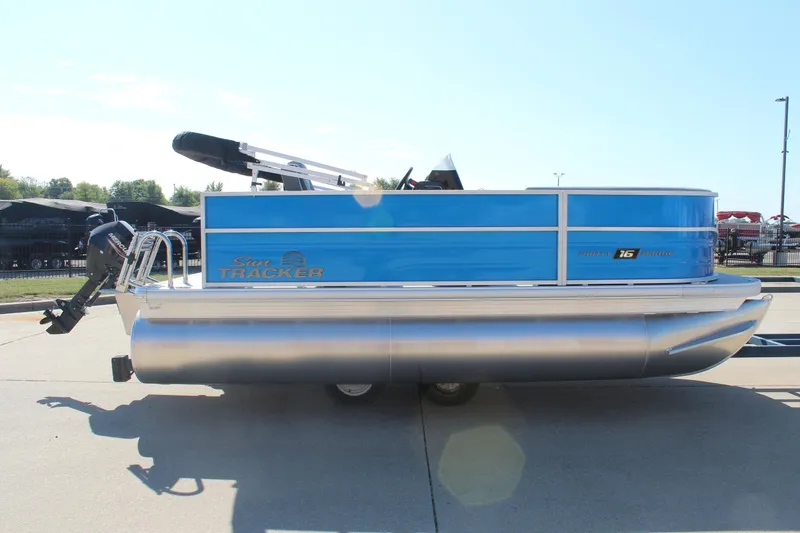 Slide: The Image of 2026 Sun Tracker Party Barge 16 DLX pontoon boat, blue exterior, parked outdoors. - 4