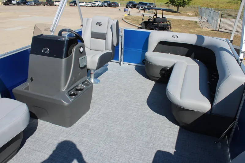 Slide: The Image of 2026 Sun Tracker Party Barge 16 DLX interior with gray seating and steering console. - 9