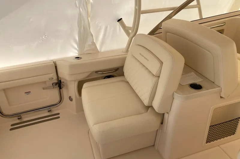 Slide: The Image of 2026 Grady-White Freedom 307 boat interior with beige seating and cup holder. - 12
